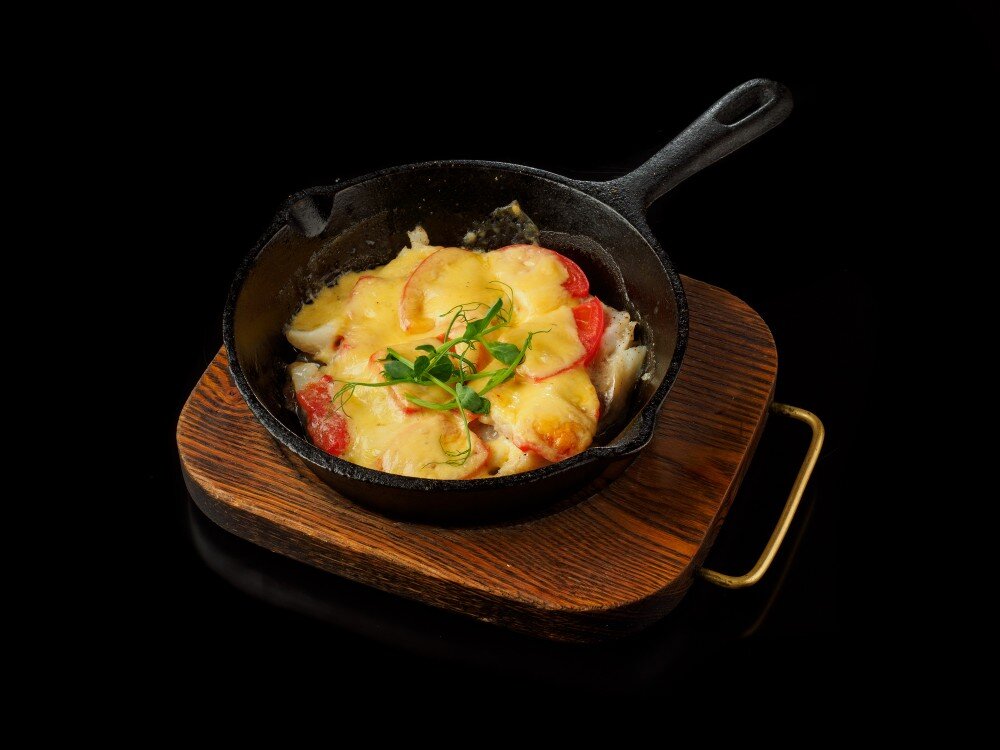 Хищница треска, спрятанная под сыром и помидорами