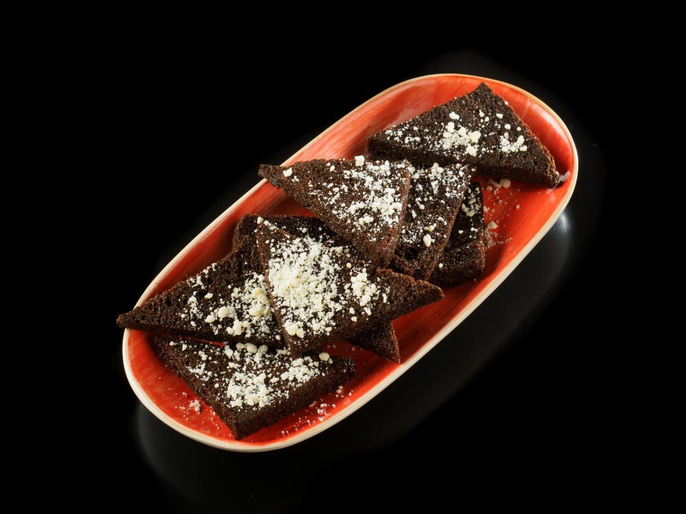 Гренки чёрные, закиданные пармезановой крошкой