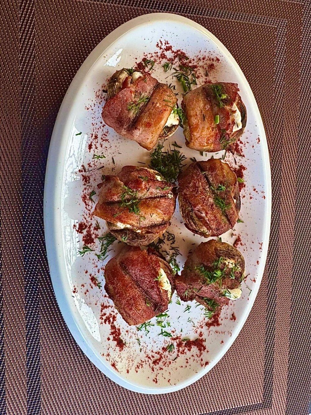Чиненые шляпки шампиньонов с сыром Фета в бекони